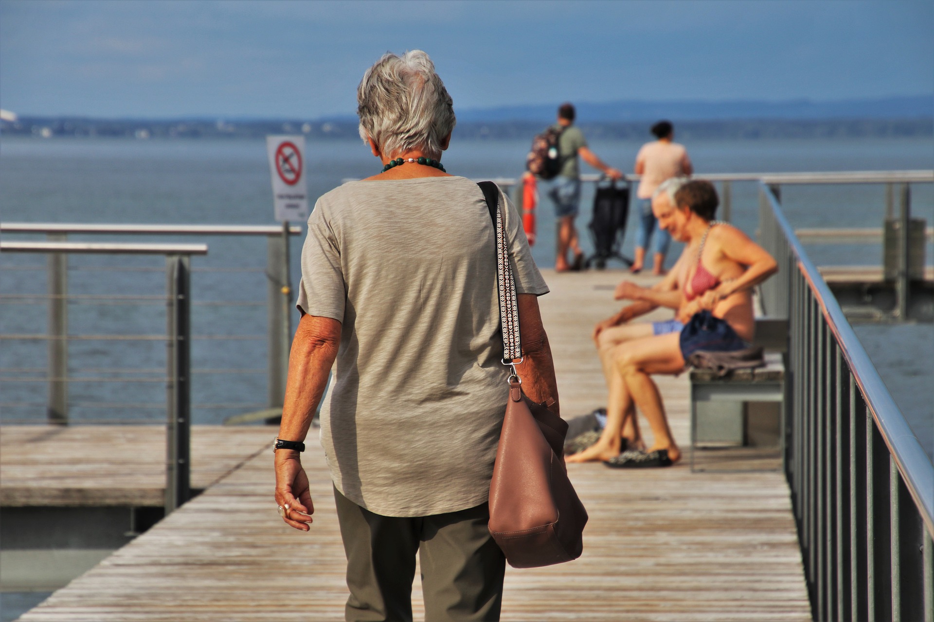 donna anziana cammina in riva al mare 
